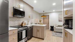 A modern kitchen with stainless steel appliances, wooden cabinets, and a central island. - Resort-style Brian Head Condo Near Slopes! (Brian Head)