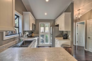 A modern kitchen with granite countertops, stainless steel appliances, and white cabinetry. - Pinehurst Gem on Golf Course & Putting Green! (Pinehurst)