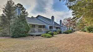 A two-story house with a covered porch and a fenced yard. - Pinehurst Gem on Golf Course & Putting Green! (Pinehurst)