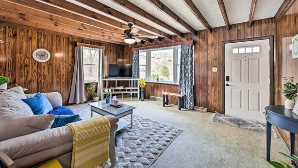 A cozy living room with a wooden ceiling, a sofa, a coffee table, and a TV. - Pet-friendly Mohnton House Near Golf Course! (Mohnton)