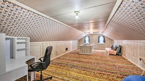 A room with a patterned ceiling, a desk with a chair, a small table, and a bed with pillows. - Pet-friendly Mohnton House Near Golf Course! (Mohnton)