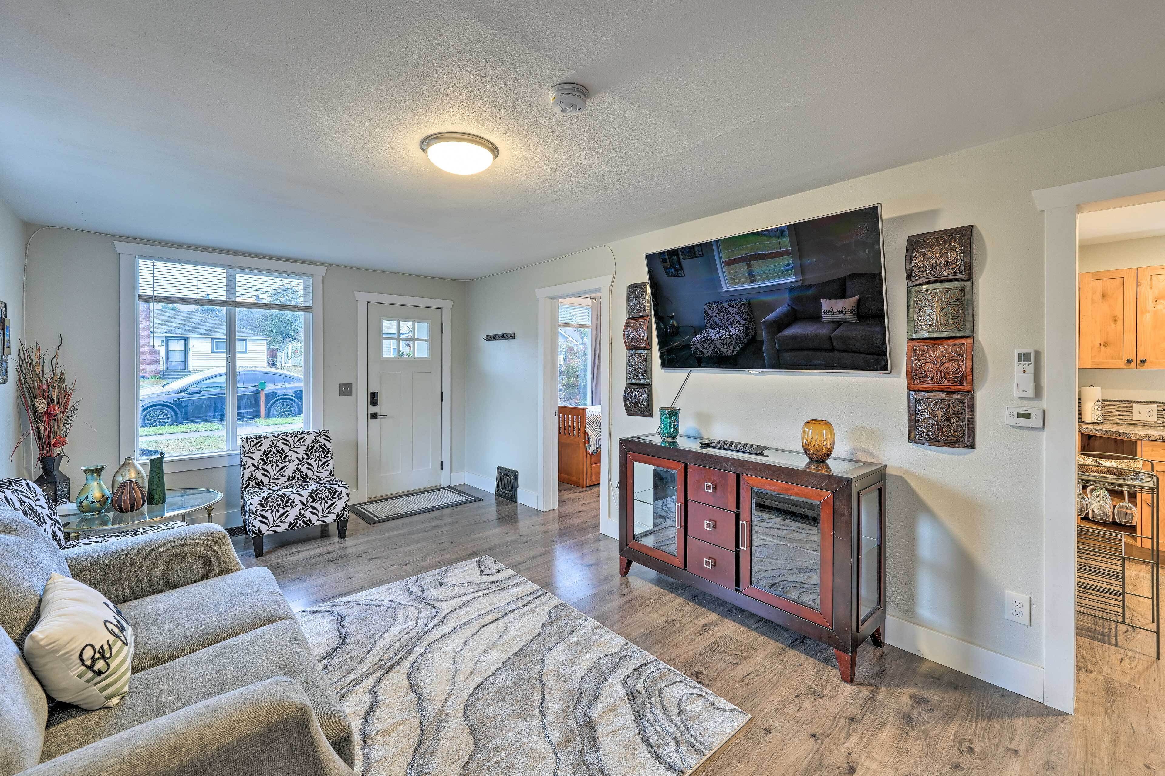 A living room with a sofa, a coffee table, a TV, and a fireplace.