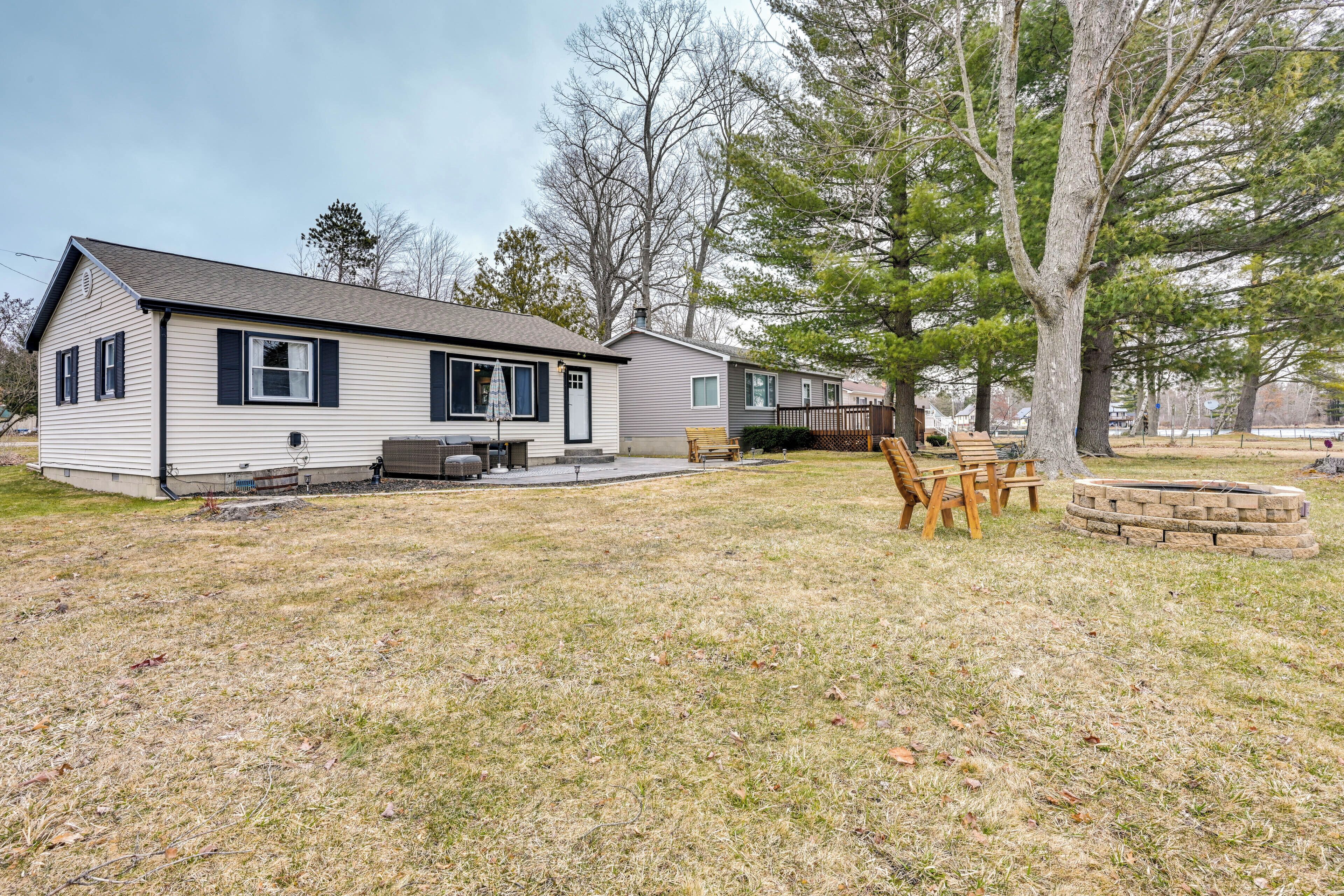 A single-story house with a front porch, a patio area, and a fire pit.