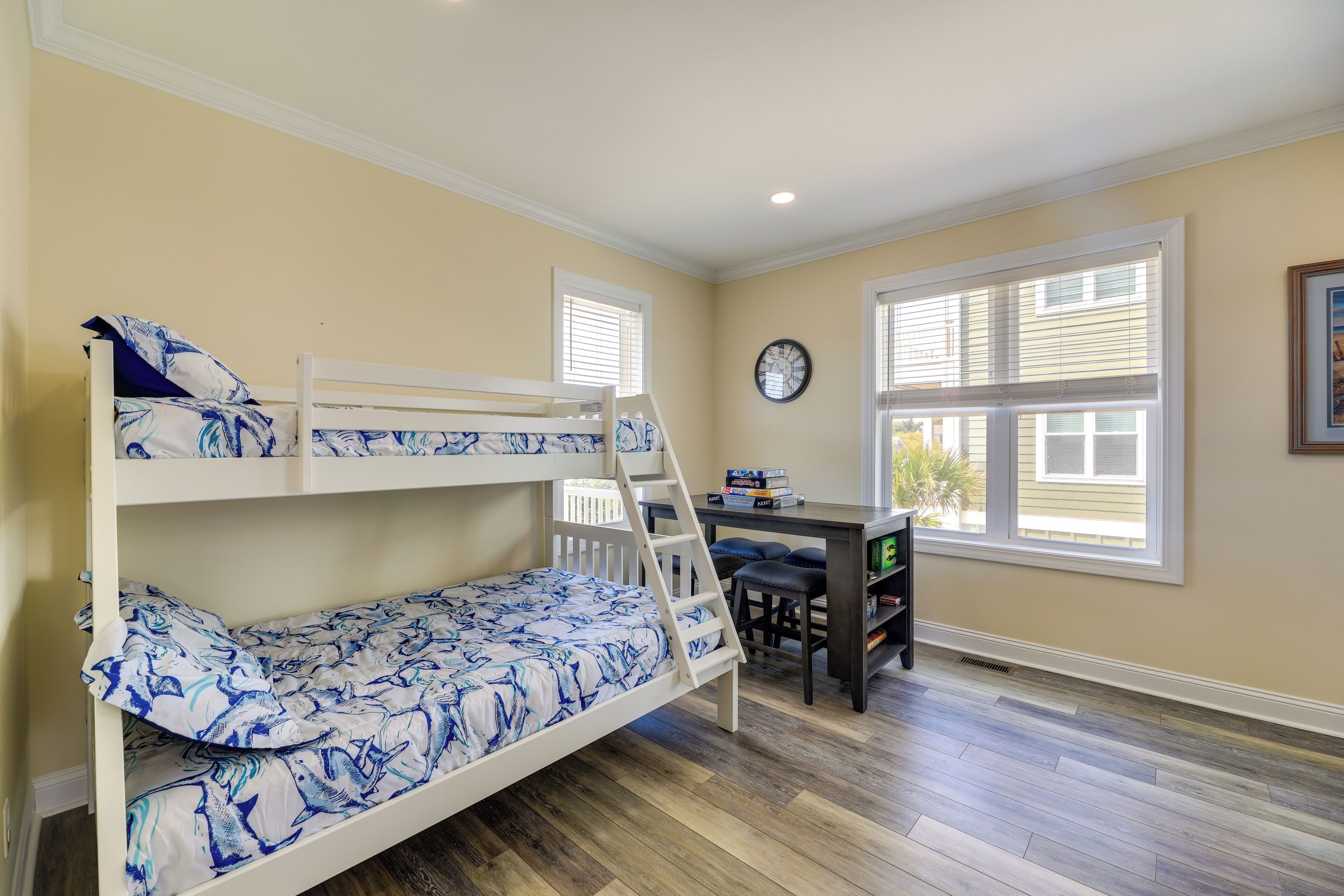 A room with bunk beds, a desk, and a chair.