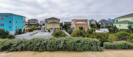A residential area with colorful houses, a swimming pool, and a well-maintained garden.