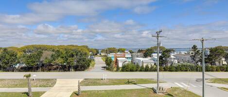 A suburban street with houses, a sidewalk, and a clear sky.
