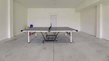 A ping pong table in a room with white walls and a door in the background.