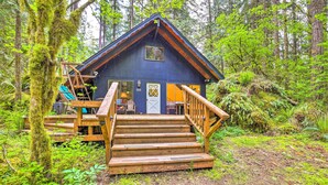 Eine Holzhütte mit einer Holzterrasse, einer Treppe und einer Tür.