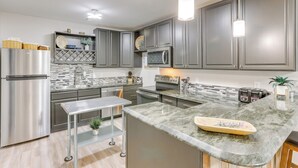 A modern kitchen with grey cabinets, stainless steel appliances, a marble countertop, and pendant lighting. - Scenic Mancos Hideaway < 2 Mi to Mesa Verde! (Mancos)