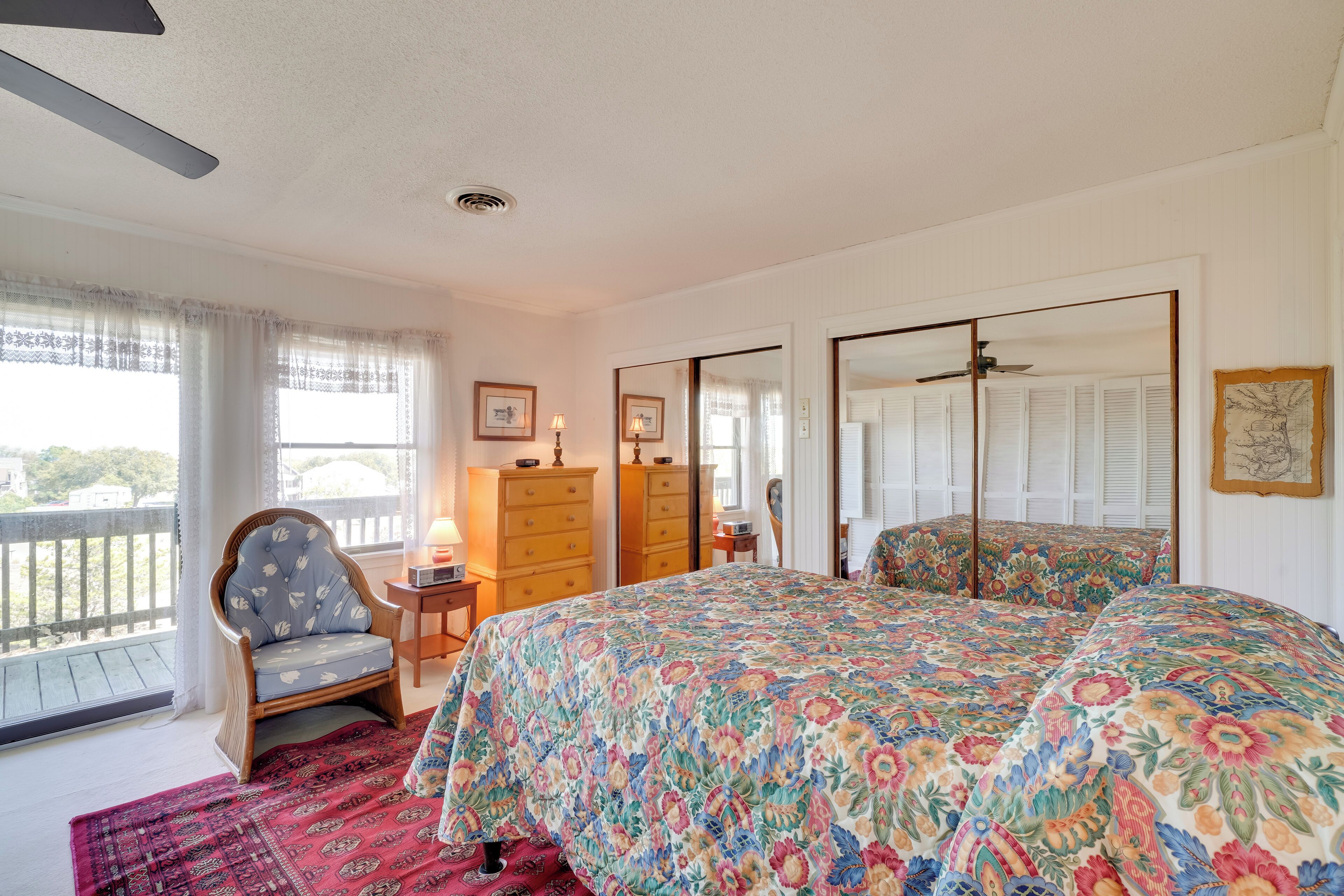 Une chambre à coucher avec un grand lit, une chaise, une commode et un miroir.