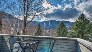 A deck with a table and chairs overlooking a mountainous landscape with snow patches. - Lincoln Escape w/ Deck: 1 Mi to Loon Mountain! (Lincoln)