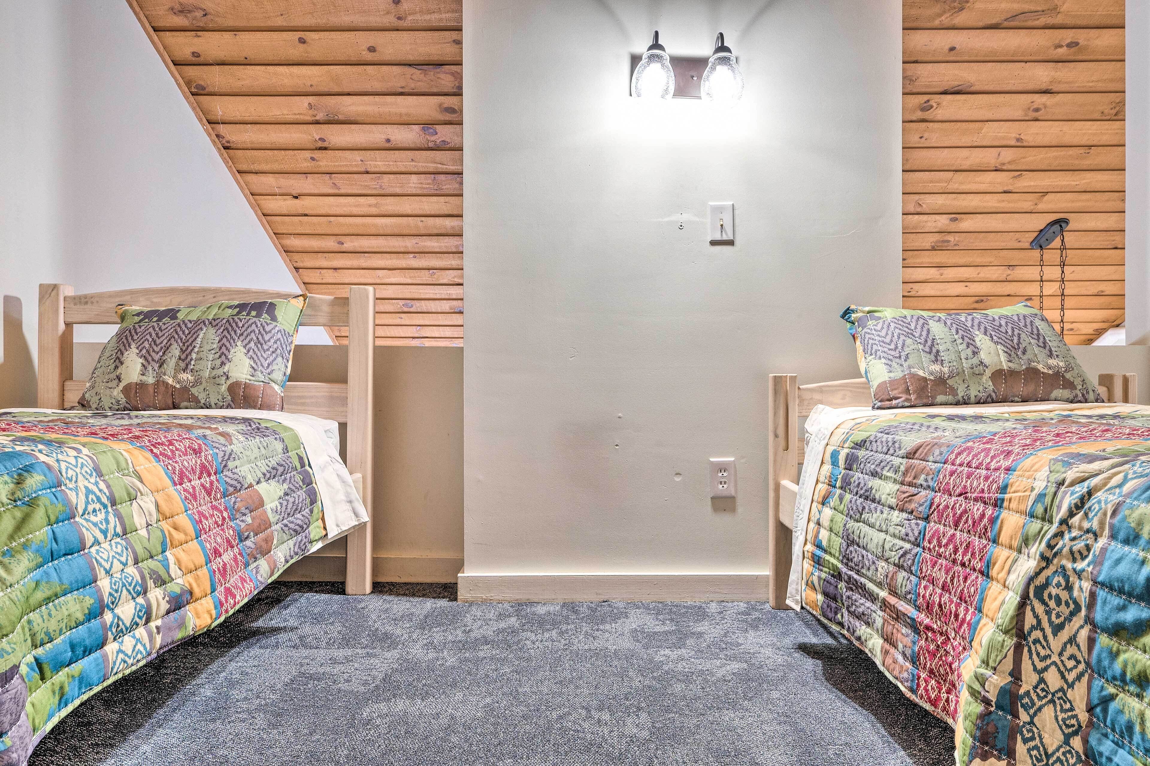 A bedroom with two wooden beds, a gray carpet, and a wooden ceiling.