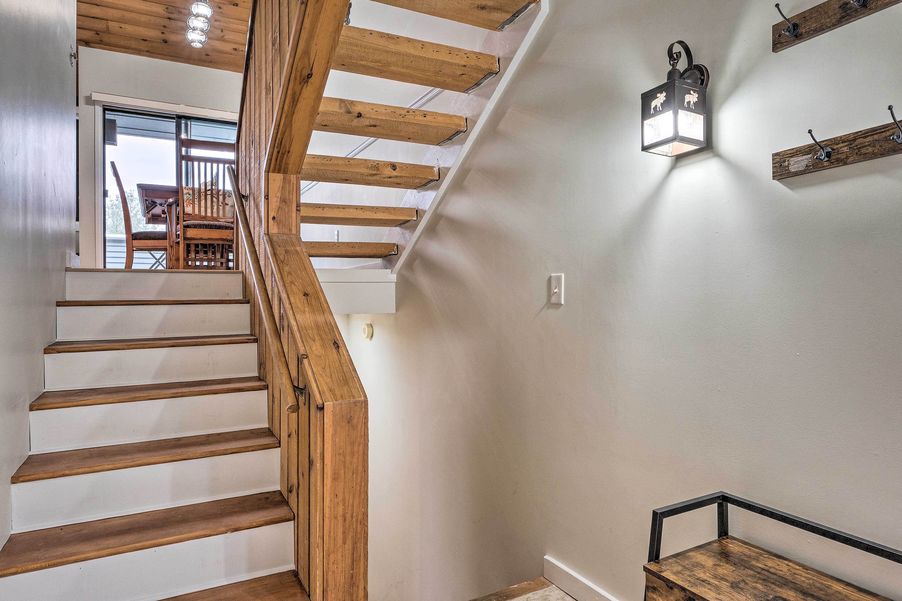 A wooden staircase with a view to a balcony.