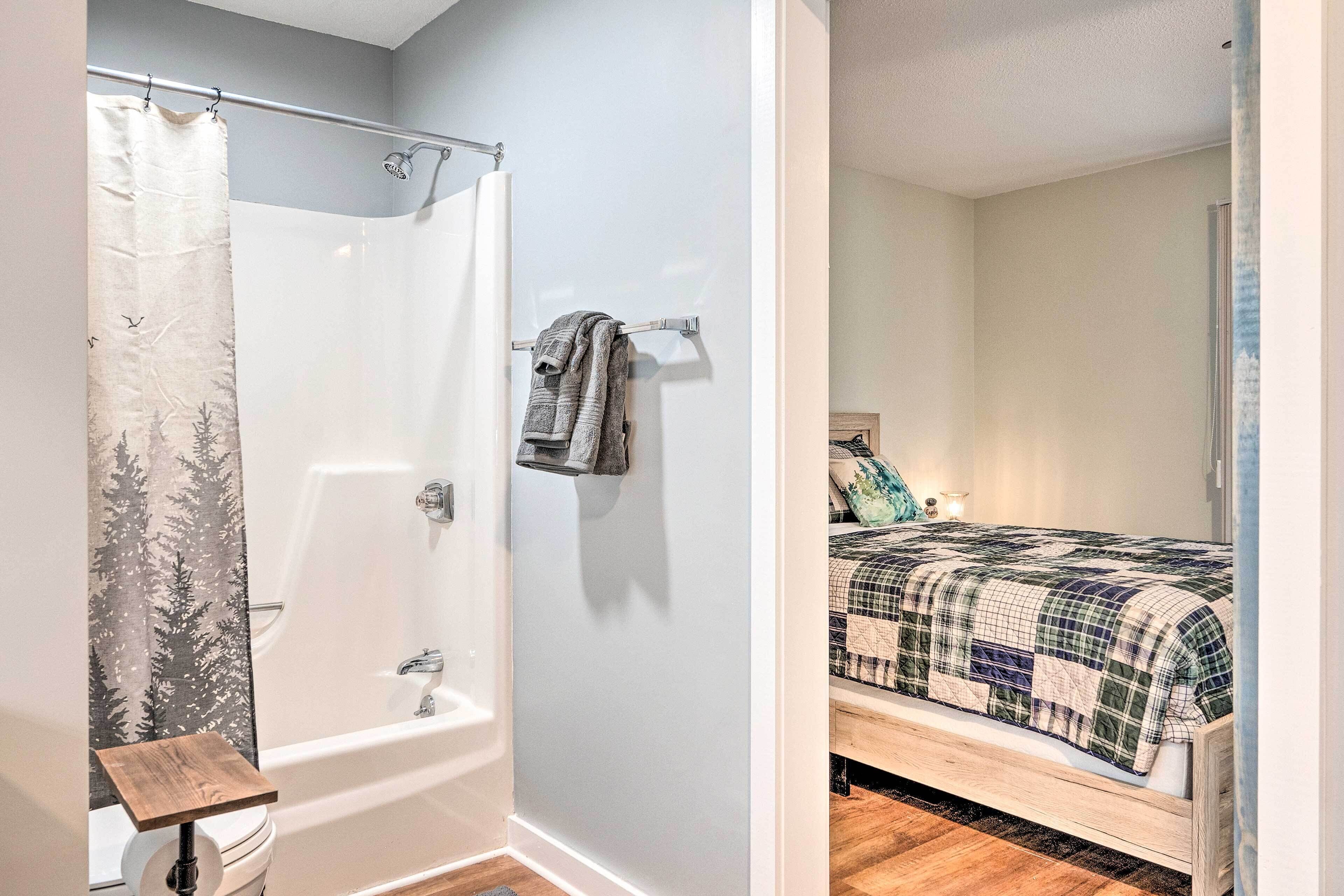 A bathroom with a shower, toilet, and a towel rack.