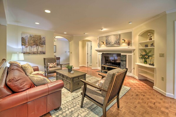 A living room with a leather sofa, wooden armchair, and a fireplace. - Easy Hiking & Sightseeing! Kingsport Home w/ Deck (Kingsport)