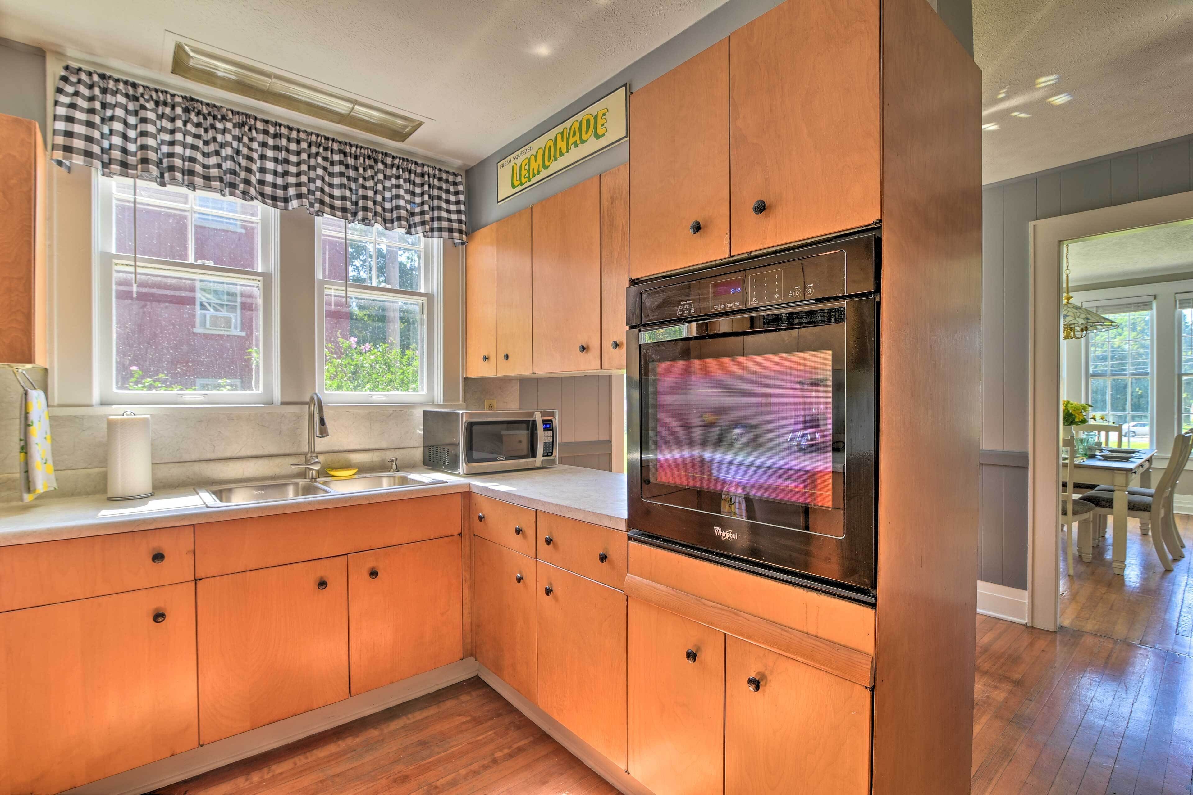 A kitchen with wooden cabinets, a stainless steel refrigerator, a microwave, and a large oven.