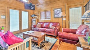 A cozy cabin interior with a wooden interior, a leather sofa, a coffee table, and a television mounted on the wall. - Deck & Dry Sauna! Fairplay 'high Creek Hideaway' (Fairplay)
