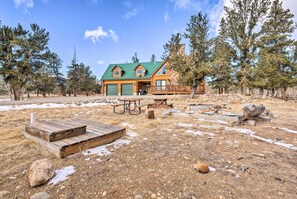 A log cabin with a green roof, a wooden deck, and a picnic table in a natural setting. - Deck & Dry Sauna! Fairplay 'high Creek Hideaway' (Fairplay)
