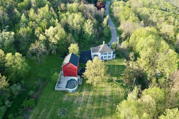 An aerial view of a property with a red barn, a white house, and a hot tub. - 6 Acres w/ Pool: Spacious Naples Vacation Rental! (Naples)