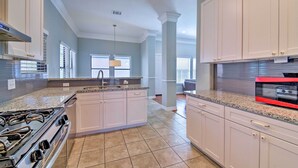 A kitchen with a central island, white cabinets, granite countertops, and stainless steel appliances. - Spacious Houston Home ~ 16 Mi to NRG Stadium! (Houston)
