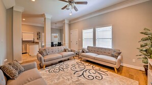 A spacious living room with two sofas, a ceiling fan, and a large rug. - Spacious Houston Home ~ 16 Mi to NRG Stadium! (Houston)