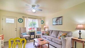 A living room with a sofa, chairs, a coffee table, a ceiling fan, and a window with curtains. - Winchester Bay Apt Near Dunes & State Parks! (Reedsport)