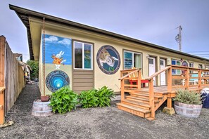 A building with a mural of a rabbit and turtle, a wooden staircase, and potted plants. - Winchester Bay Apt Near Dunes & State Parks! (Reedsport)