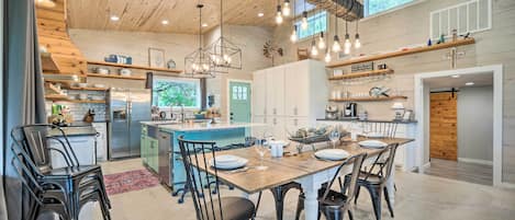 A spacious kitchen with wooden ceiling, modern appliances, and a central island.