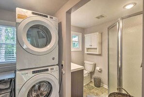 A laundry room with stacked washers and dryers, a toilet, and a shower area. - Blowing Rock Home: 1 Block to Downtown! (Blowing Rock)
