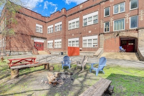A courtyard with a picnic table, fire pit, and outdoor seating.