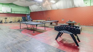 A sports hall with multiple foosball tables, a ping pong table, and a table tennis table. - Access to Warrior Trail! ATV Base Camp in Gary (Gary)
