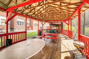 A covered outdoor area with picnic tables, a barbecue grill, and a large white table. - Access to Warrior Trail! ATV Base Camp in Gary (Gary)