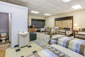 A dormitory room with four wooden beds, a white sink, a blackboard, and a bulletin board with photos. - Access to Warrior Trail! ATV Base Camp in Gary (Gary)