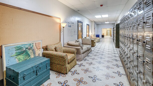 A hallway with lockers, a map on the wall, and a patterned floor. - Access to Warrior Trail! ATV Base Camp in Gary (Gary)