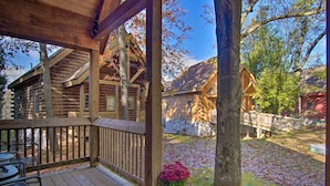 A wooden cabin with a porch, stone wall, and a wooden bridge. - Rustic Rothbury Cabin w/ Resort Amenity Access! (Rothbury)