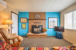 A living room with a fireplace, a clock, a television, and a sofa. - Tropic Family House - 10 Miles to Bryce Canyon! (Tropic)