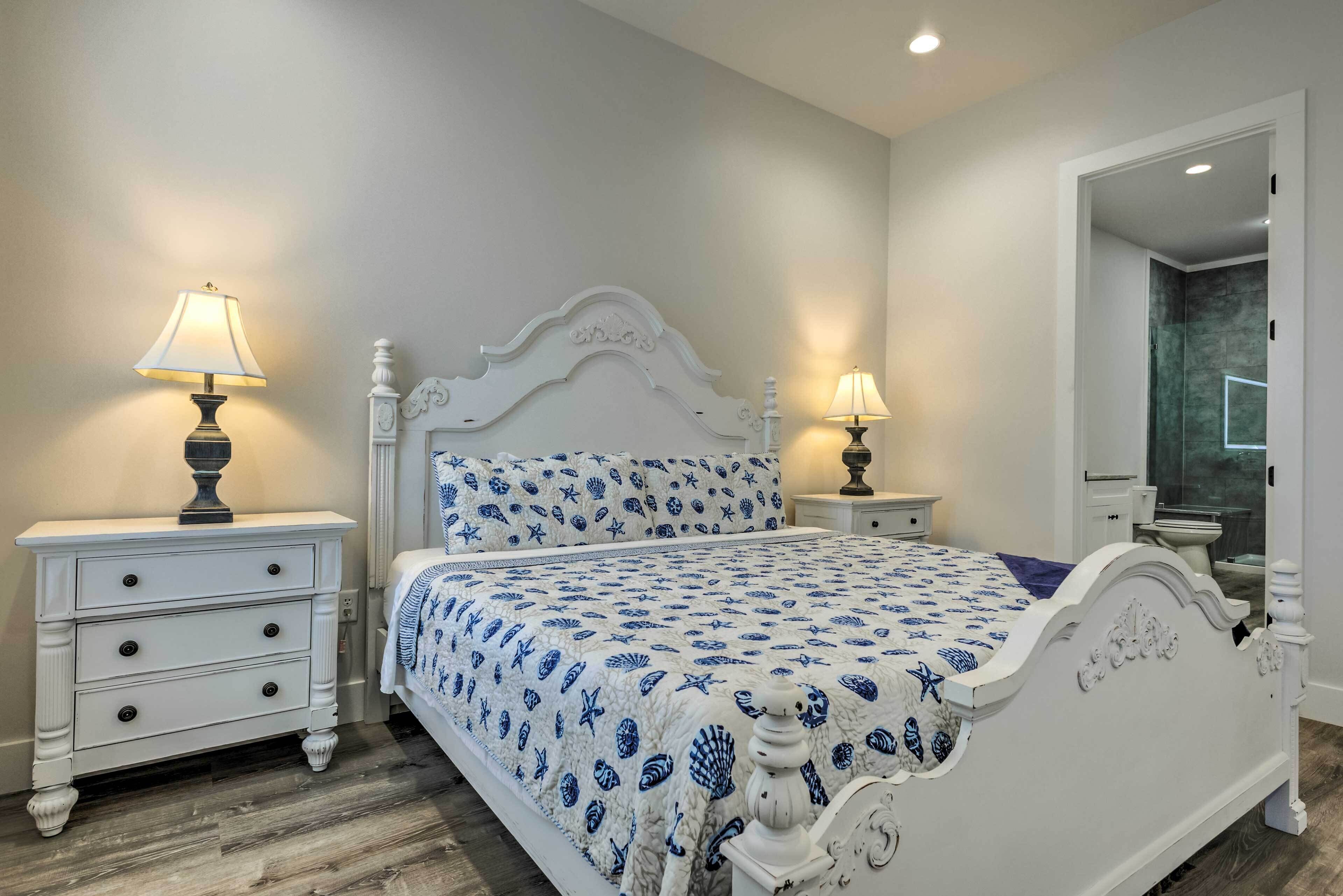 Un dormitorio con una cama, dos mesitas de noche y un espejo.