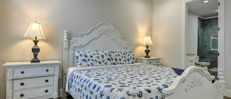 Un dormitorio con una cama, dos mesitas de noche y un espejo.