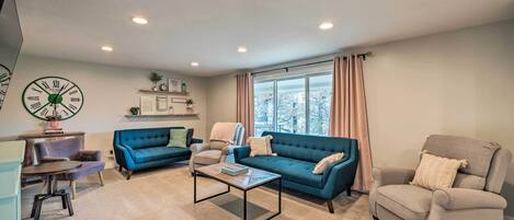 A living room with a blue sofa, beige armchair, and a coffee table.