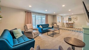 Een moderne woonkamer met een blauwe bank, beige fauteuils en een salontafel.