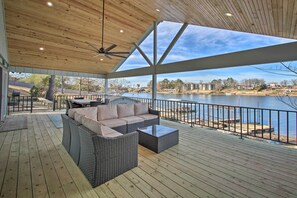 A covered outdoor deck with wicker furniture and a view of a lake. - Waterfront Getaway w/ Dock on Lake Hamilton! (Hot Springs)