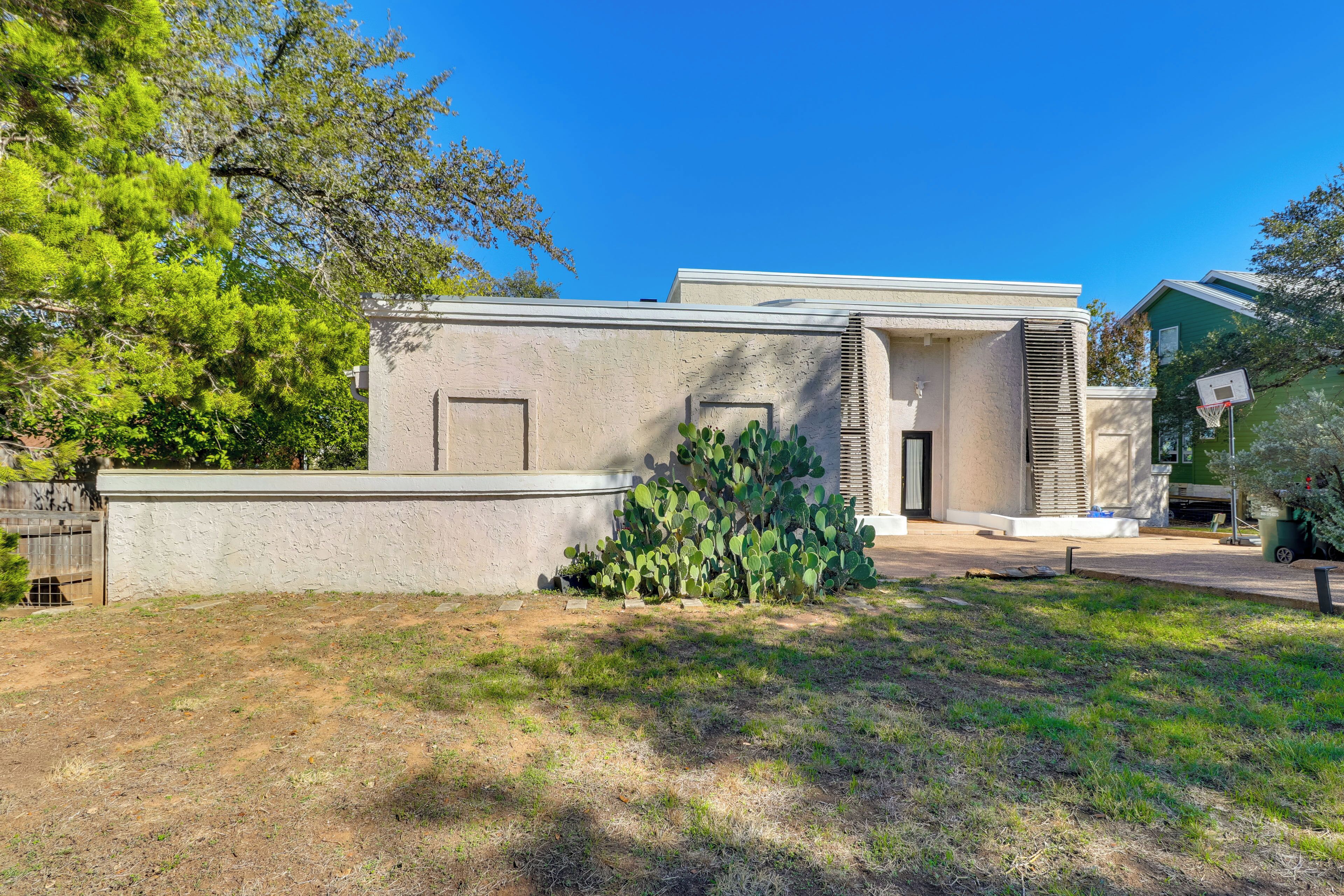 A modern house with a flat roof, a front door, and a small patio area.