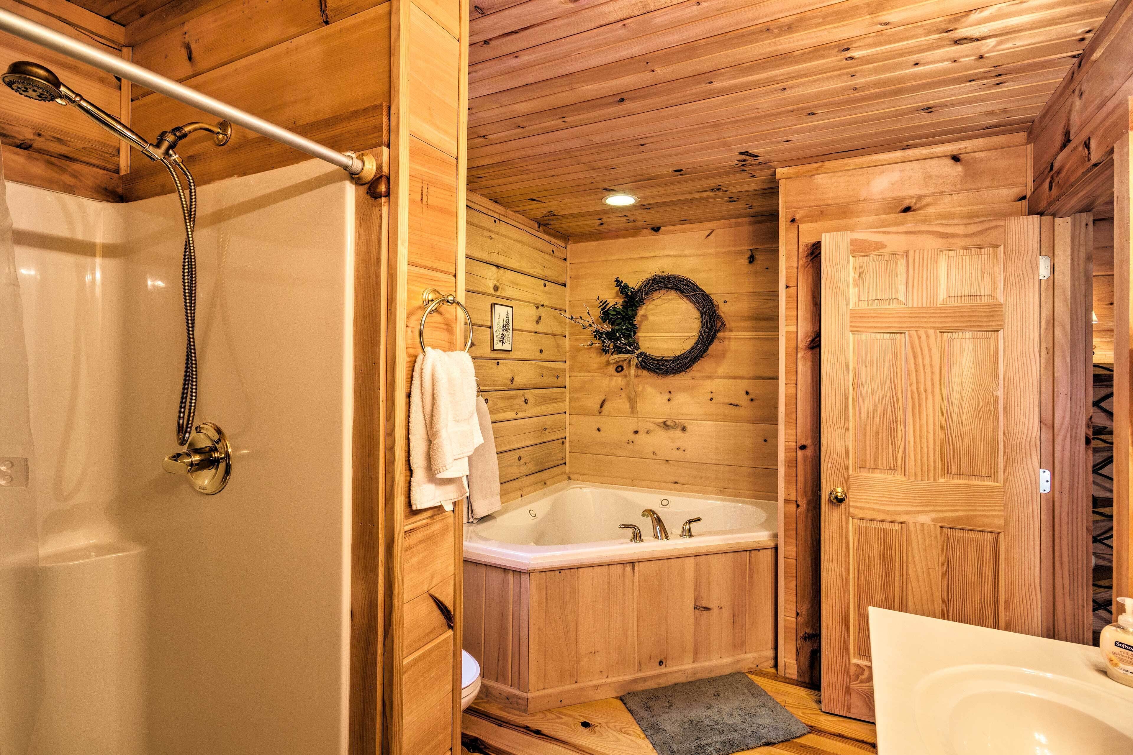 A wooden cabin bathroom with a shower, a bathtub, and a toilet.