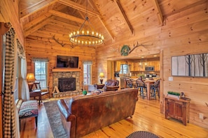 A cozy log cabin interior with a fireplace, a large wooden ceiling, and a dining area. - Waynesville Escape - Mtn Cabin Above the Clouds! (Waynesville)