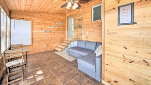 A wooden cabin interior with a sofa, a chair, a ceiling fan, and a staircase. - On-site Boat Launch: Gun Barrel City Lake House (Mabank)