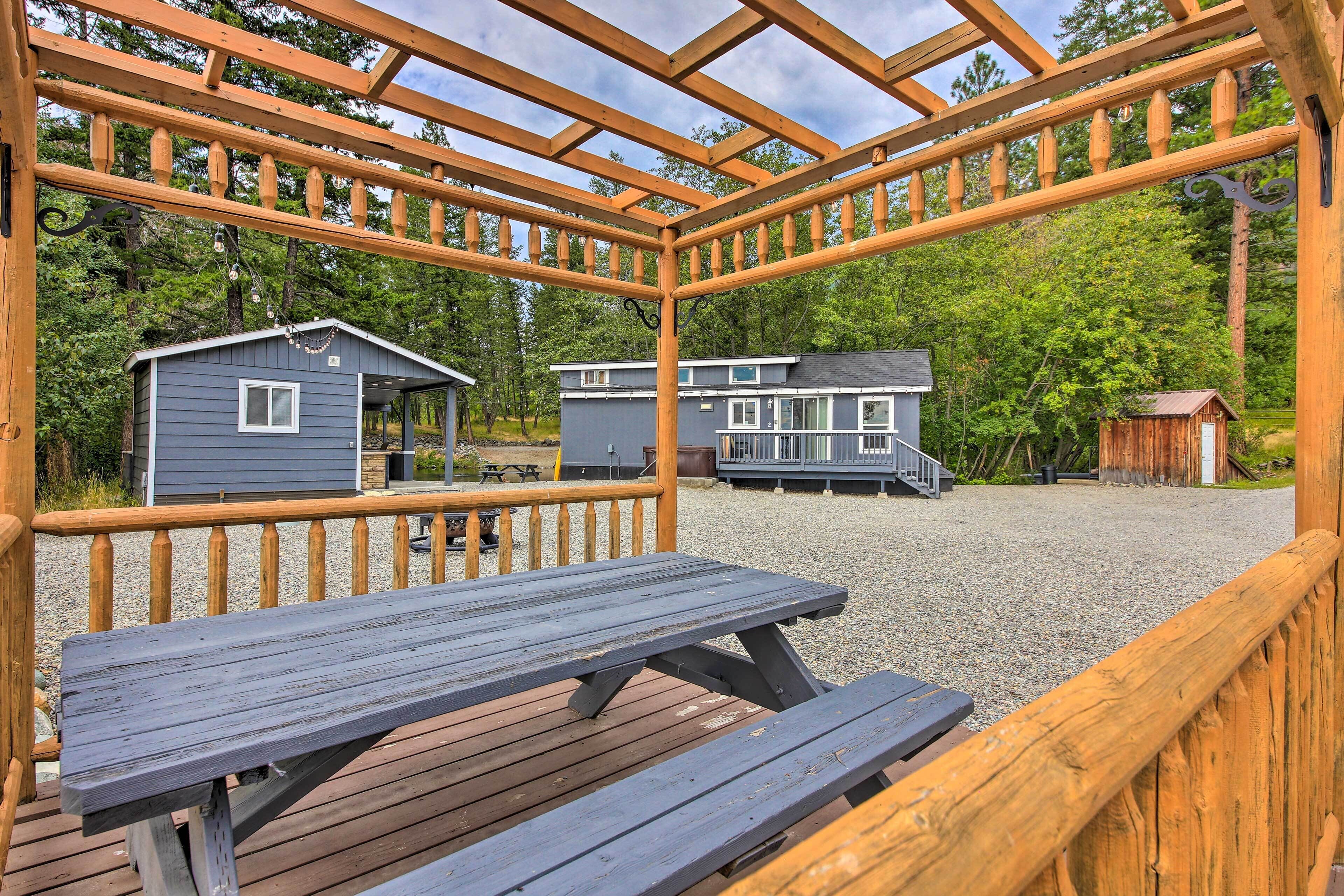 A wooden deck with picnic tables and a gazebo structure.