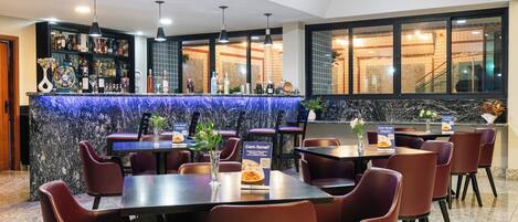 A restaurant with a bar area, seating, and a view of the interior.