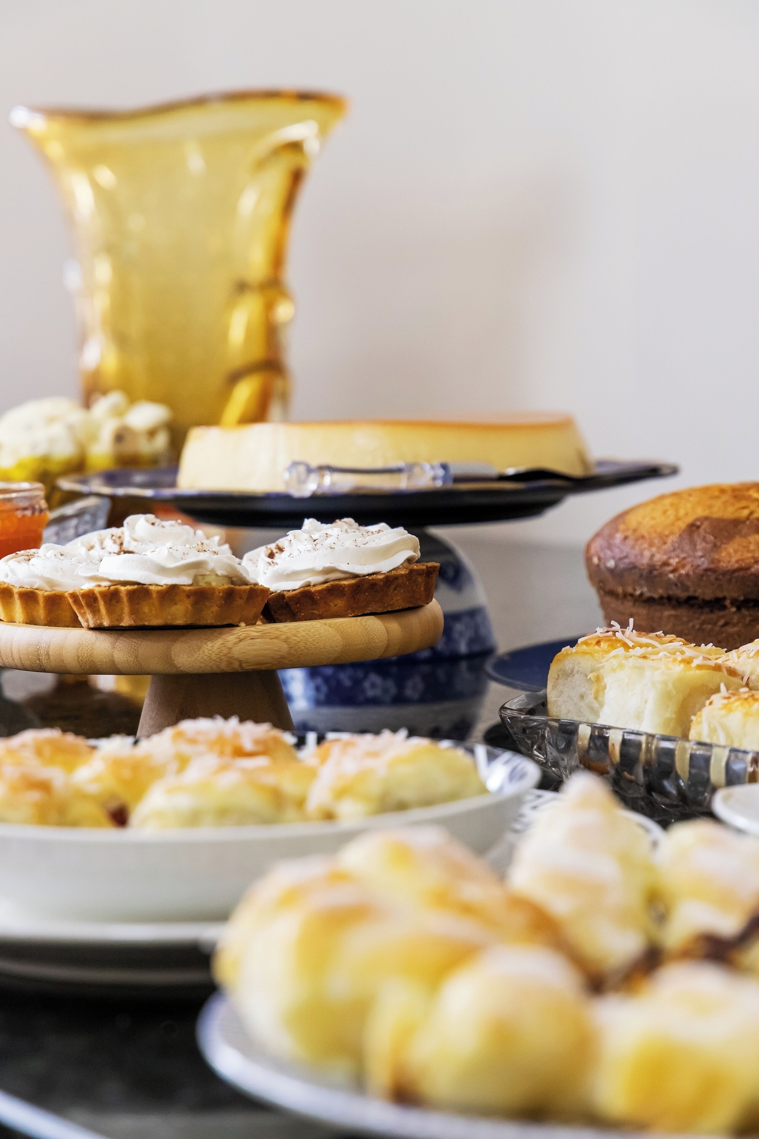 A variety of baked goods including pies, tarts, and pastries on a wooden serving board.