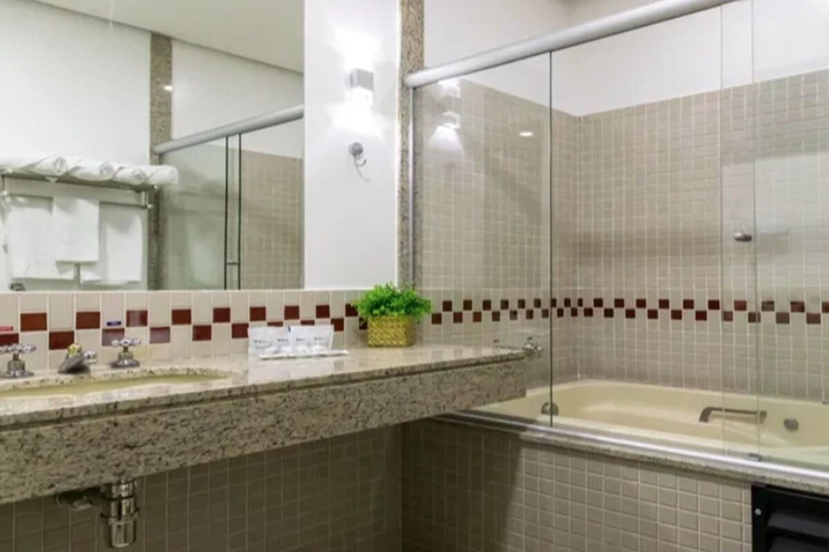 A bathroom with a sink, mirror, and bathtub.