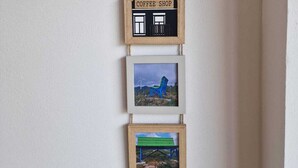 A wall-mounted decoration with a coffee shop sign, two framed pictures of chairs, and a wooden frame. - Le randonneur (Garessio)